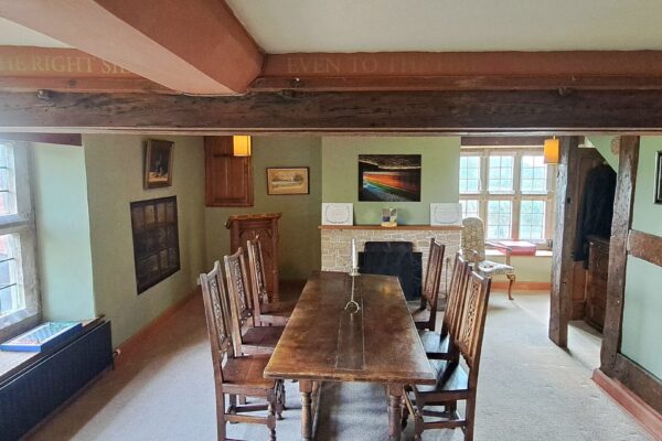 a green room in a Tudor hall, with a large oak table