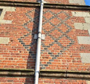 The 2Ã—16 cell diamond brickwork: one for each piece; Soulton Hall's design with pawn-topped finals symbolizing philosophical codes, aims to elevate visitors like pawns becoming queens.