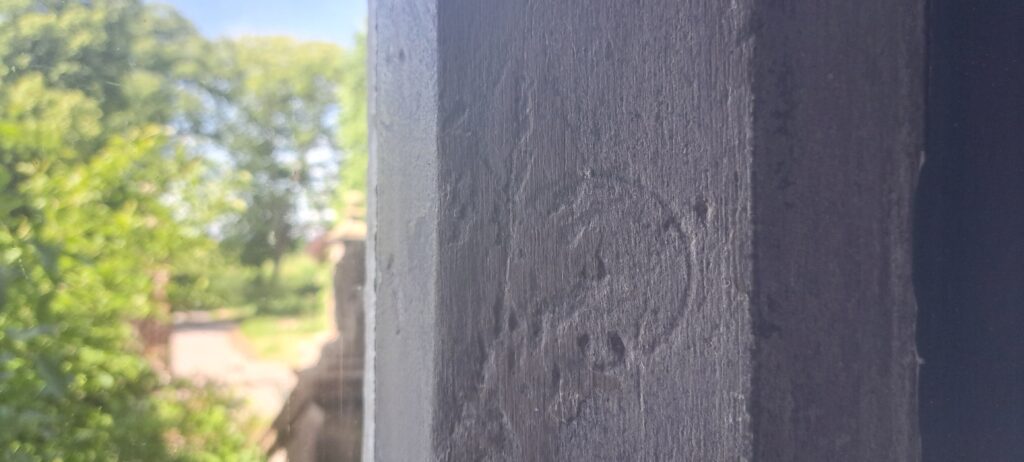 Slightly warn circle carved in the north Hall Hall Windows in Soulton Hall: possibly a representation of The Dance