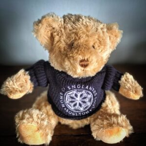 A Teddy Bear wearing a blue jumper