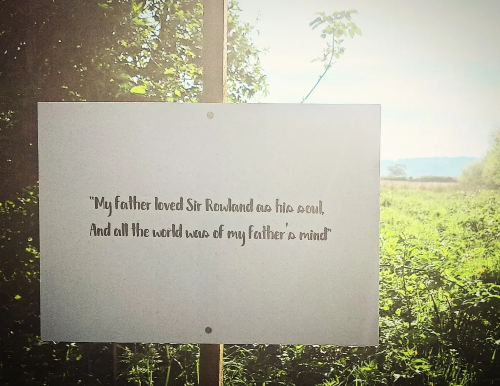 Sign inthe SOulton landscape looking at the Old Sir Rowland monument, quoting AS YOU LIKE IT: 'My father loved Sir Rowland as his soul, And all the world was of my father's mind'