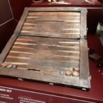 The backgammon board provides a rare look at the moments of leisure aboard, serving as a reminder that even in the midst of a naval voyage, the men sought to pass the long hours with familiar games of strategy and chance.