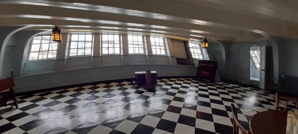 In his private day cabin, which served as his office and strategy room, the deck was covered with a painted canvas floorcloth decorated in a black-and-white geometric tile square pattern known to the navy as Nelson's checker.